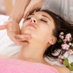 ragazza-distesa-occhi-chiusi-che-si-sta-facendo-fare-massaggio-viso