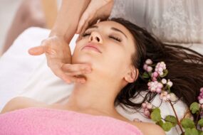 ragazza-distesa-occhi-chiusi-che-si-sta-facendo-fare-massaggio-viso