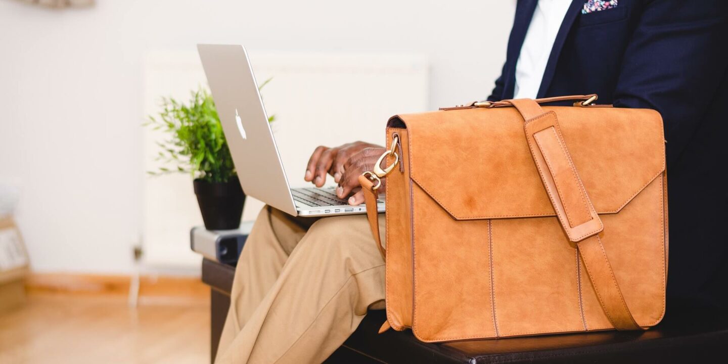 primo-piano-busto-uomo-seduto-portatile-borsa-lavoro