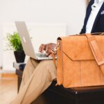 primo-piano-busto-uomo-seduto-portatile-borsa-lavoro