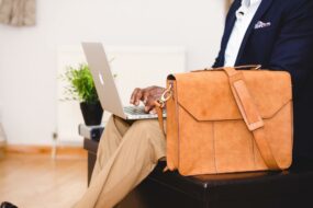 primo-piano-busto-uomo-seduto-portatile-borsa-lavoro